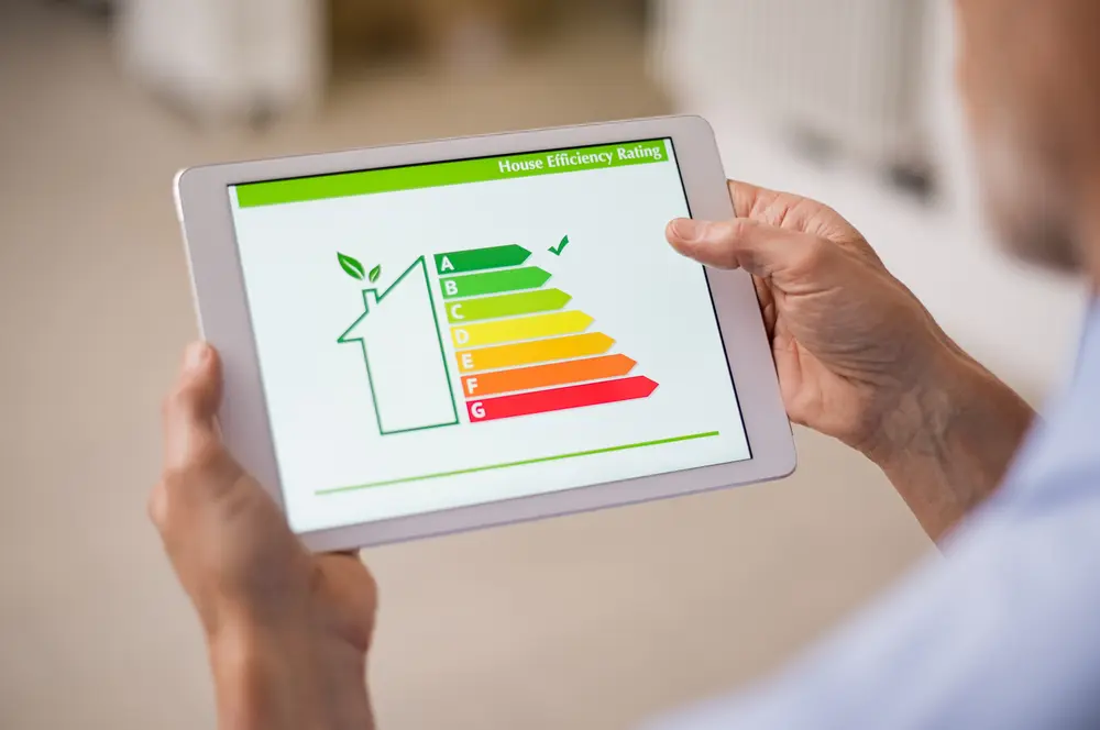 Tankless Water Heater vs. Tank: Which is Right for You? - Charles Stone – Heating and Cooling Hand holding digital tablet and looking at house efficiency rating. Detail of house efficiency rating on digital tablet screen. Concept of ecological and bio energetic house. Energy class.