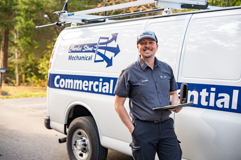 Charles Stone Mechanical technician standing in front of company branded van