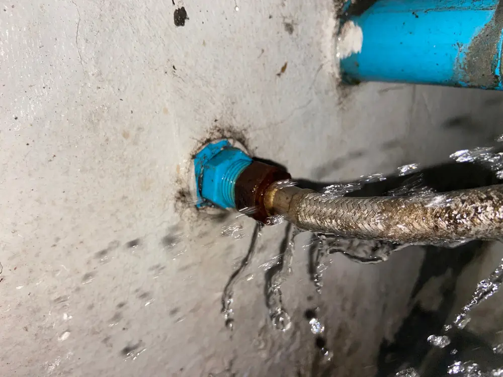 Rusty burst pipe spraying water
