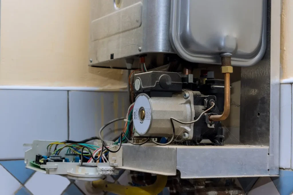 Technician worker looking inside gas heater trying to fix the problem